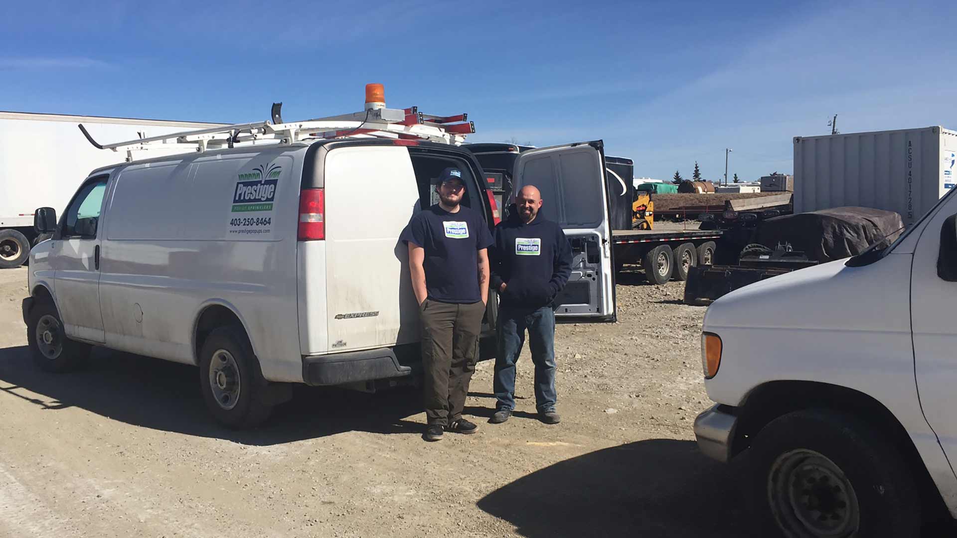 Justin and Daryl by the Prestige Outdoor Services work fleet near Calgary, Alberta.