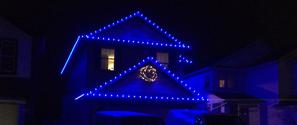 A home decorated with blue holiday lighting in Airdrie, AB.