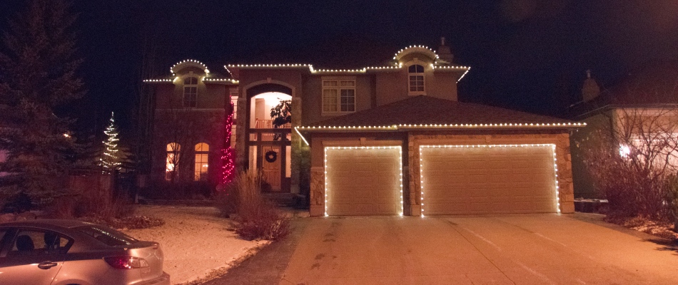Holiday lights decorated around a perimeter of a home in Lake Bonavista, AB.