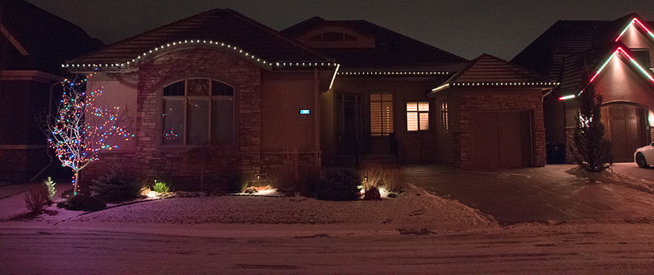 A home decorated with holiday lights in Aspen Woods, AB.