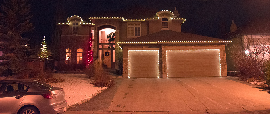 A house on a hill decorated with holiday lighting in Bearspaw, AB.