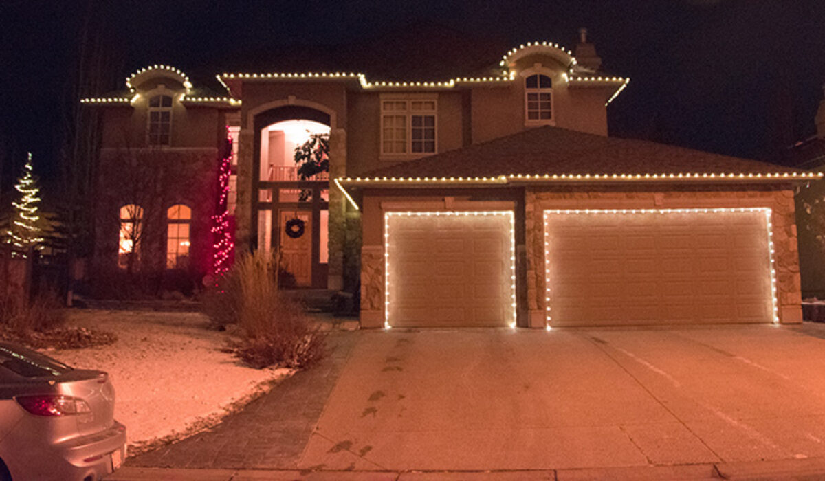 content house on hill decorated with holiday lights