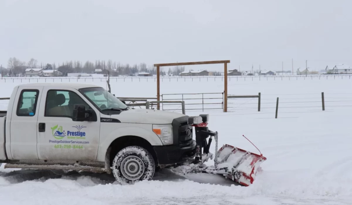 Prestige Outdoor Services plow truck clearing snow in Calgary after a monitored winter storm.